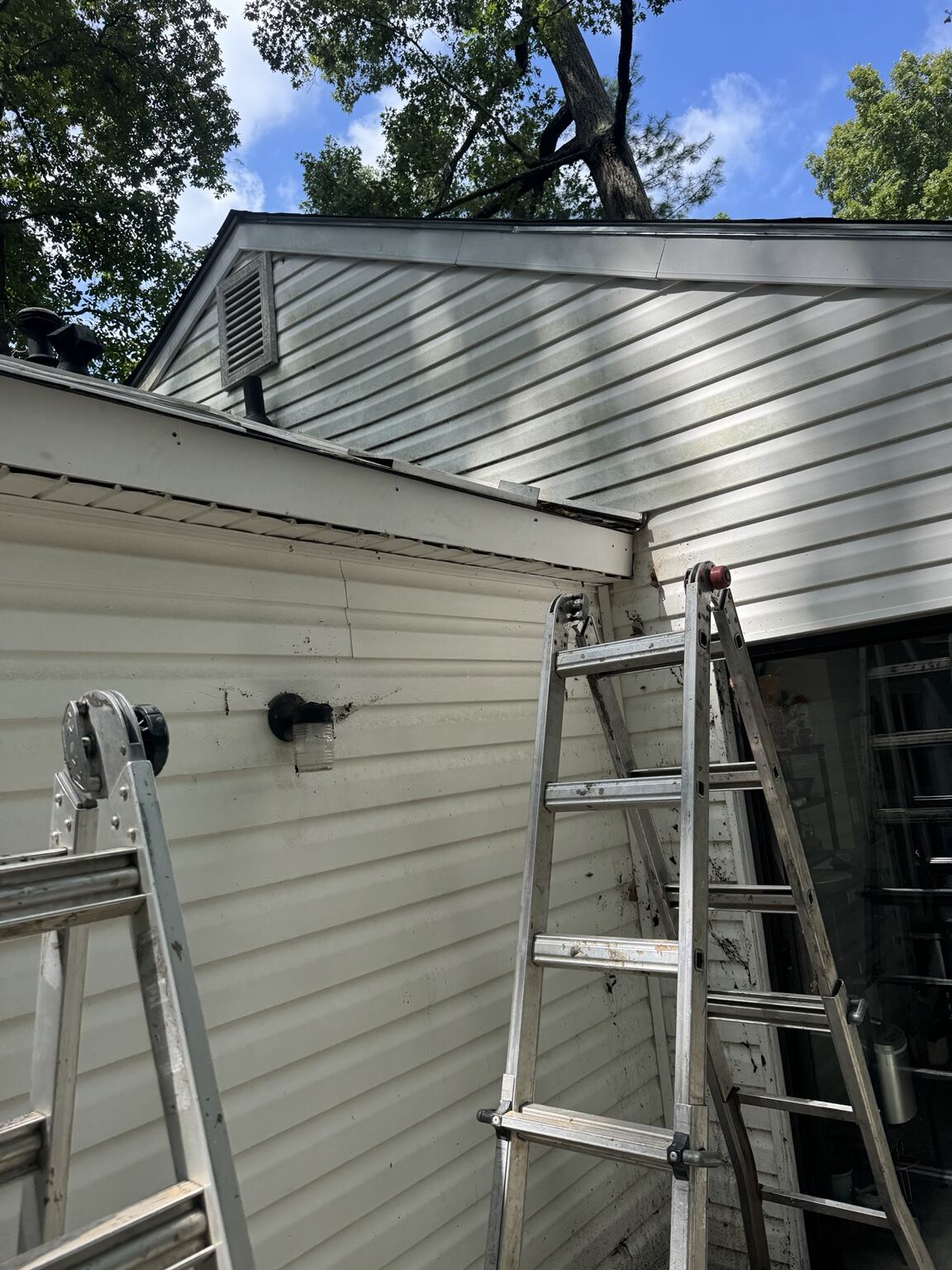Ladders staged along a home during fascia and soffit replacement