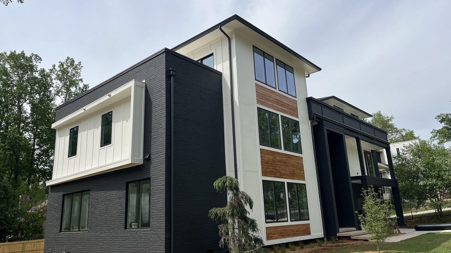 Modern black-and-white Metro Atlanta home with new dark seamless gutters and downspouts along the roofline