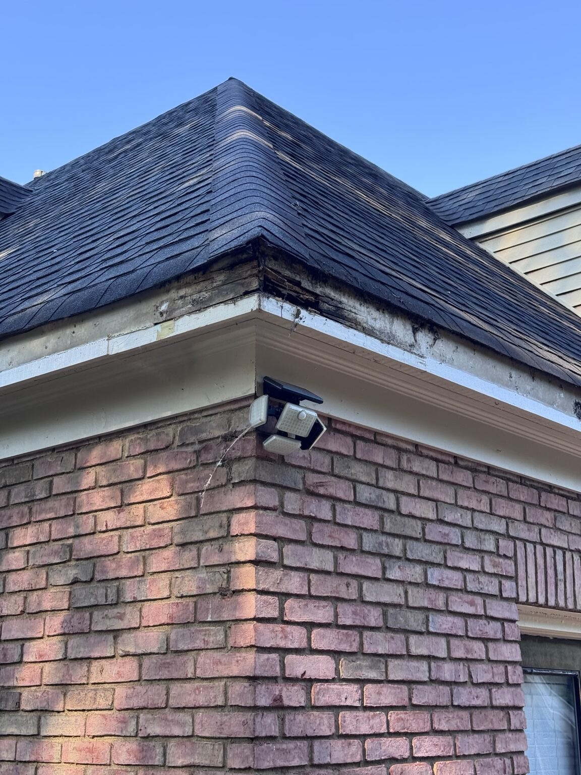 Worn fascia and gutter line on a brick quadplex building before service