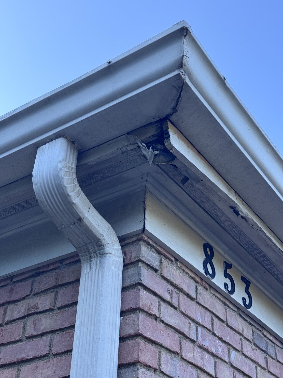 New downspout and gutter detail on a brick apartment building