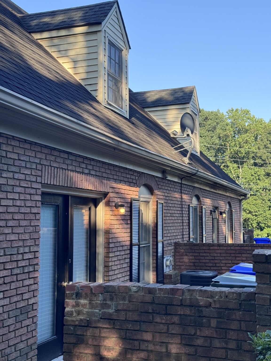 Brick multifamily building with dormers and serviced gutter line