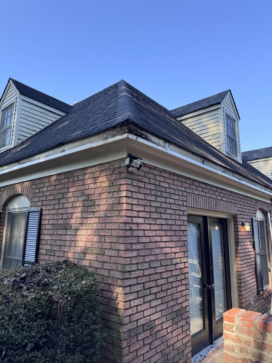 Brick apartment building corner with clean fascia and gutter line