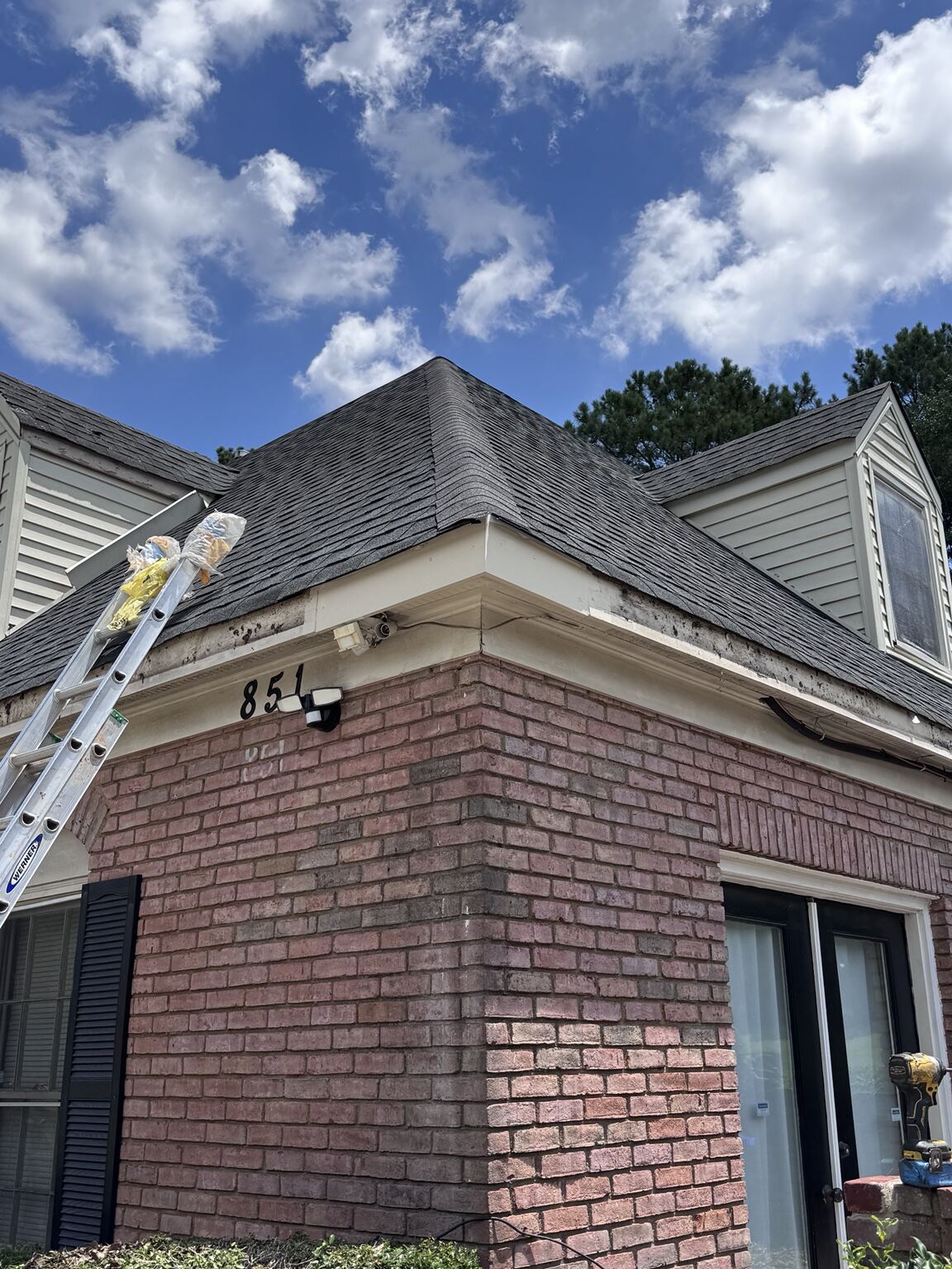 Ladder at the roofline of a multifamily unit during gutter work